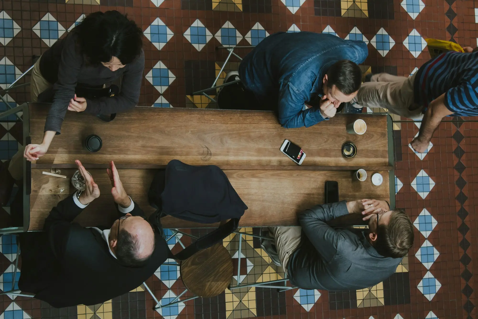 Overhead view of business owners meeting over plans at a café table in The Strand Arcade, Sydney